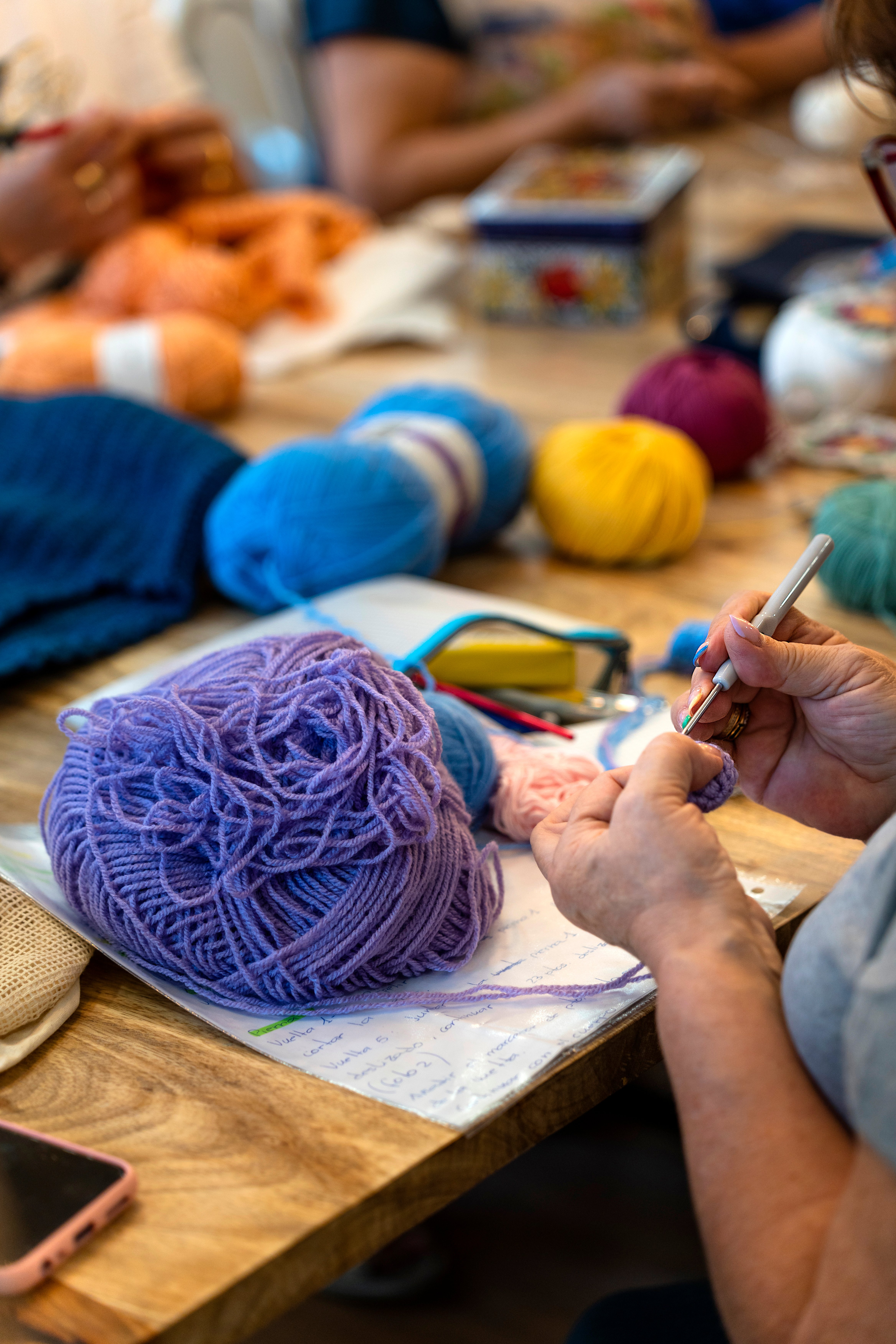 Crochet club. Hands of an elderly woman knitting with wool.
